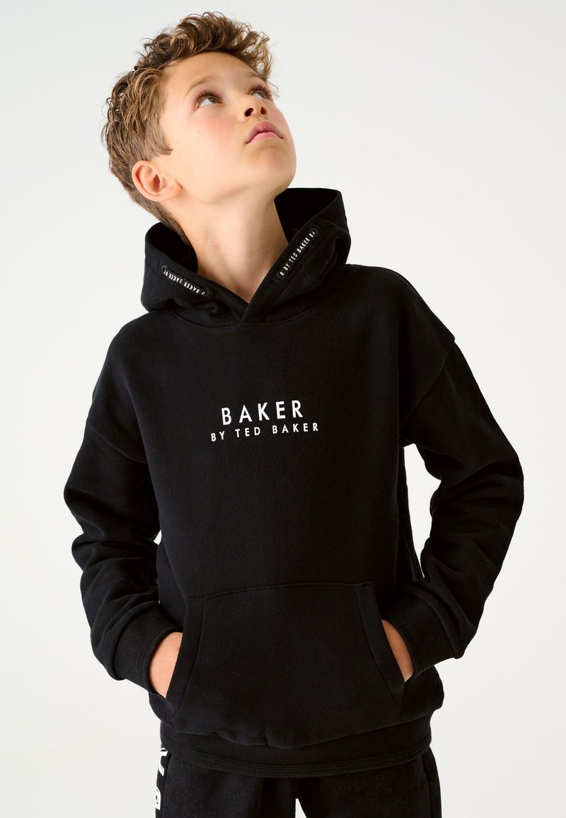 Must kapuutsiga dressipluus esitaskuga, millel on valged tähed "BAKER BY TED BAKER." Pehme kangas, mugav lõige, soonikkoes mansetid.