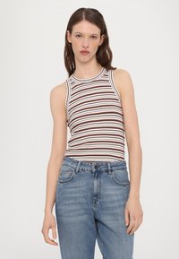 Top de tirantes a rayas en marrón y blanco, con textura acanalada y escote redondo. Combinado con jeans de mezclilla de tiro alto en azul claro.