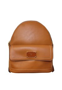 Zaino in pelle marrone chiaro con parte superiore arrotondata, tasca frontale piatta, cuciture bianche e una placca con logo in metallo. Presenta una chiusura con zip e spallacci regolabili.