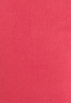 Close-up van roze stof met een diagonale keperweefstructuur die gedetailleerde textuur en vezels toont.