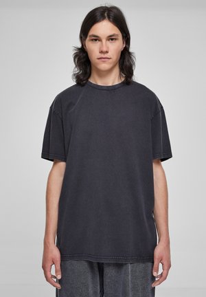 Zwarte oversized t-shirt gemaakt van katoen. Heeft een ronde halslijn, korte mouwen en zichtbare stiksels. Zachte textuur. Casual pasvorm.