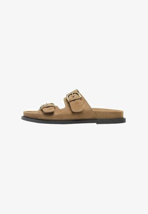 Hnedá semišová šľapka so dvoma nastaviteľnými remienkami s prackami a čiernou plochou podrážkou, bočný pohľad.