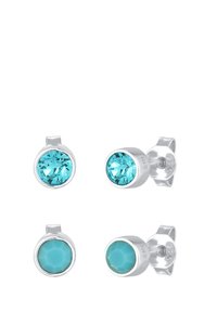 Boucles d'oreilles en argent ornées de deux pierres turquoise : l'une ronde et facettée, l'autre ronde et lisse. Détails de sertissage avec poinçon visible.