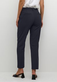 Marinblå skräddarsydda byxor med smal passform, med bakfickor, en slät textur och medelhög midja, i kombination med svarta blockklack-sandaler.