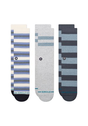 Trois paires de chaussettes courtes dans des tons bleus et gris avec divers motifs de rayures horizontales et le nom de la marque près des orteils.