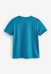 Camiseta de algodón turquesa con mangas cortas, escote redondo y una textura suave. La parte posterior no presenta gráficos ni adornos.