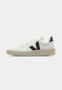 White leather sneaker with black V logo, perforated toe, cream rubber sole, flat lace closure, and minimalist design.