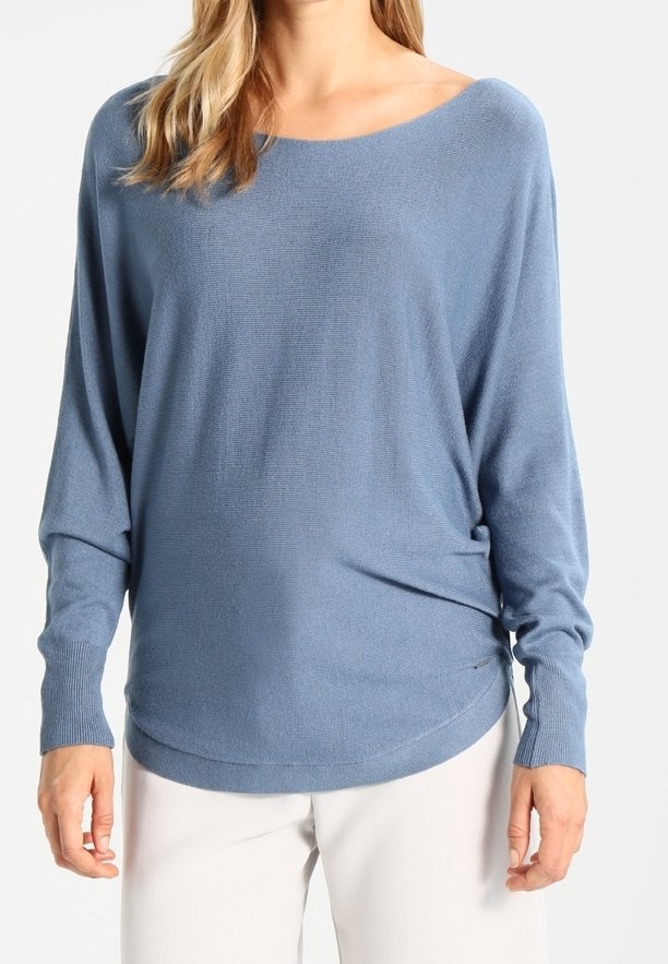 Hellblauer, locker geschnittener Pullover mit weitem Ausschnitt und überschnittenen Schultern. Weiche Textur, gerippte Bündchen und ein abgerundeter Saum.