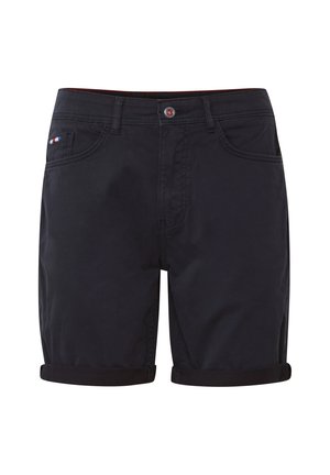 Sötét tengerészkék, pamut keverékből készült sort, felgöngyölt szegéllyel, elülső zsebekkel és egy apró háromszínű logóval a bal oldali zseben.