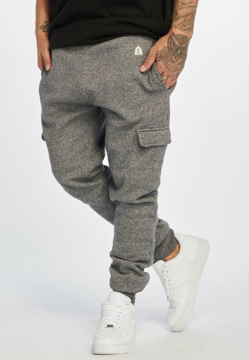 Gray fleece joggers with cargo pockets, tapered cuffs, and a small logo on the back. Paired with white sneakers.