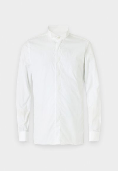 Chemise blanche à manches longues avec col montant, fermeture à boutons et coupe ajustée. Texture lisse, poignets à un bouton et style minimaliste.