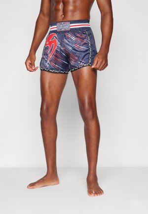 Dark blue swim shorts with red graphic design, elastic waistband with white and red stripes, and contrasting stitching detail.
