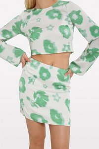 Haut à manches longues cropped à motif floral vert et mini-jupe assortie, fabriqués en tissu texturé avec une apparence légère.