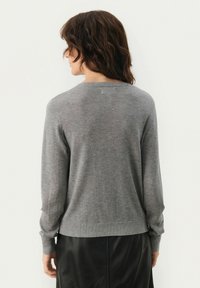 Gray knit sweater with a crew neckline, ribbed cuffs, and hem. Textured fabric, relaxed fit, and back view highlighting smooth lines.
