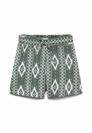 Pantalones cortos verdes con patrones geométricos de diamante blancos y una pretina con cordón frontal, dispuestos sobre un fondo blanco.