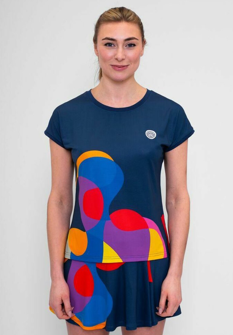 Top azul marino con patrones geométricos coloridos en naranja, rosa y púrpura; mangas cortas, cuello redondo y un parche con el logotipo en el pecho.
