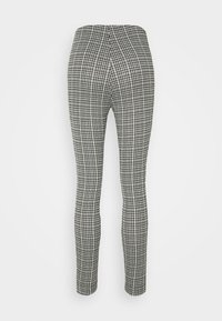 Svart och vit houndstooth-mönstrade leggings, figurnära design, slät textur, hög midja, utan synliga knäppningar eller dekorationer.