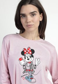 Camisa de manga larga rosa con un personaje de dibujos animados sosteniendo un teléfono inteligente, con un lazo de lunares, una chaqueta de estampado de leopardo y zapatillas azules.