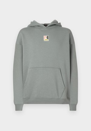 Szara bluza z kapturem, z przednią kieszenią i małą naszywką z logo w kolorach różowym, białym i czarnym na wysokości klatki piersiowej. Klasyczny fason.