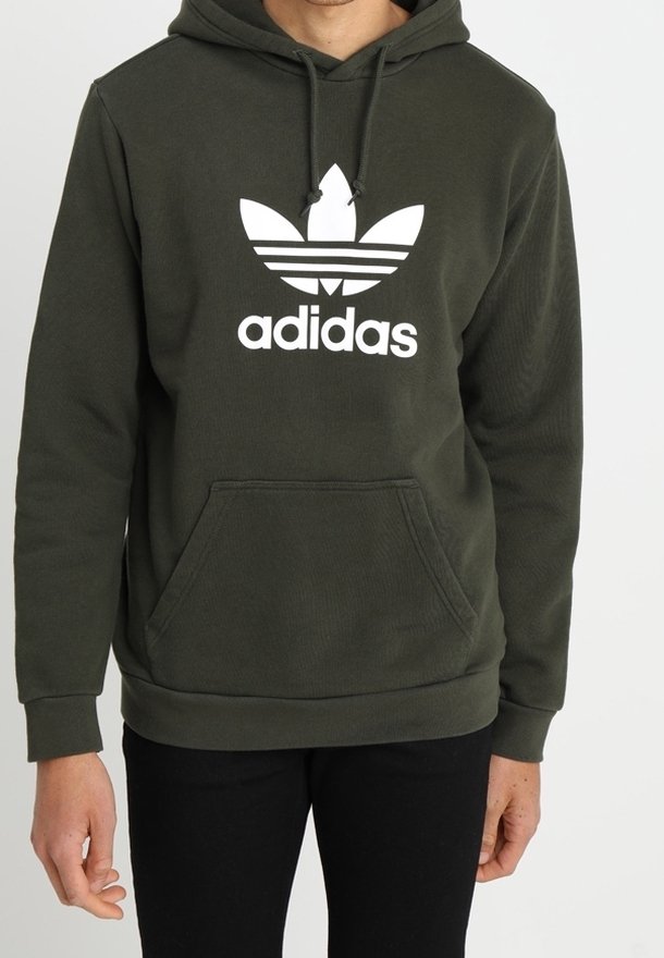 Olivgrön hoodie med framficka, dragsko i huvan och vit Adidas treklöverlogotyp. Tillverkad av texturerat tyg med en avslappnad passform.
