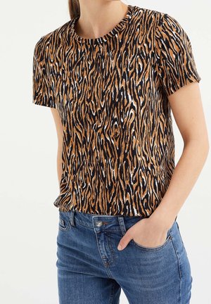 Tričko s krátkým rukávem v černé, oranžové a bílé zvířecí potisku. Má kulatý výstřih, slim fit a jemnou texturu. Nosené s modrými džíny.