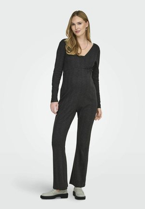Charcoal gray jumpsuit with long sleeves, V-neck, fitted bodice, flared legs, soft texture, paired with light gray shoes.