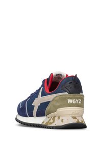 Sneaker in suede e mesh blu navy con accenti beige chiaro, fodera rossa, tallone verde e suola decorata. Presenta il logo del marchio sul lato.