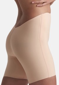 Nude, strakke shapeshorts gemaakt van glad, rekbaar materiaal; mid-thigh lengte met een naadloos ontwerp en geen zichtbare naden.