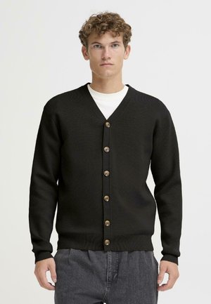 Cardigan noir avec un col en V et sept boutons sur le devant. Il dispose de poignets et d'un ourlet côtelés, fabriqué en tissu tricoté texturé.