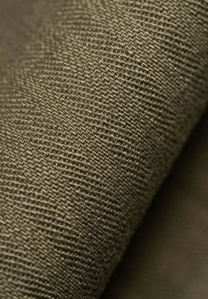 Tessuto di color verde oliva con una trama a tessitura sottile, che mostra fibre fini e una leggera lucentezza. Il tessuto appare spesso e durevole.