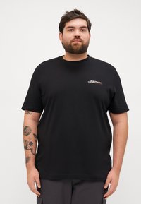 Tricou negru din bumbac, cu guler rotund și mâneci scurte, având un logo mic imprimat pe pieptul stâng. Textură fină, croială relaxată.