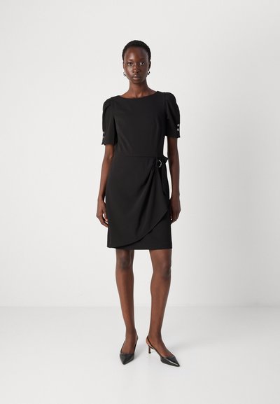 Robe noire avec des manches bouffantes, un décolleté carré, un design enroulé sur le côté et un accent circulaire. Tissu lisse et coupe mi-longue.