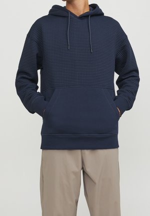 Felpa con cappuccio blu navy, caratterizzata da un pannello superiore testurizzato, tasca frontale e polsini a coste, realizzata in un morbido tessuto misto cotone.