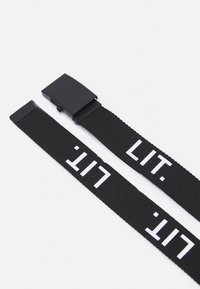 Čierny látkový opasok s obdĺžnikovou čiernou prackou, na ktorej je biely nápis "LIT.". Popruh má štruktúrovaný tkaný vzor.