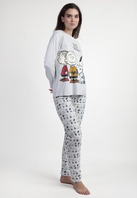 Camiseta de pijama de manga larga gris con personajes de dibujos animados; pantalones de pijama grises con un estampado repetido de personajes, ambos hechos de tela suave.