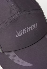 Tumši pelēks sporta cepure ar struktūru audumu, izšūti akcenti un smalks logotips, papildināts ar gludu vizieri.
