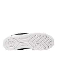 Baskets noires avec une tige texturée noire, présentant une semelle en caoutchouc blanche avec un motif de bande de zigzag et des accents circulaires.