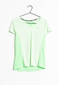 Camiseta de running Nike verde claro con cuello en V y mangas cortas colgando de una percha negra sobre un fondo blanco.