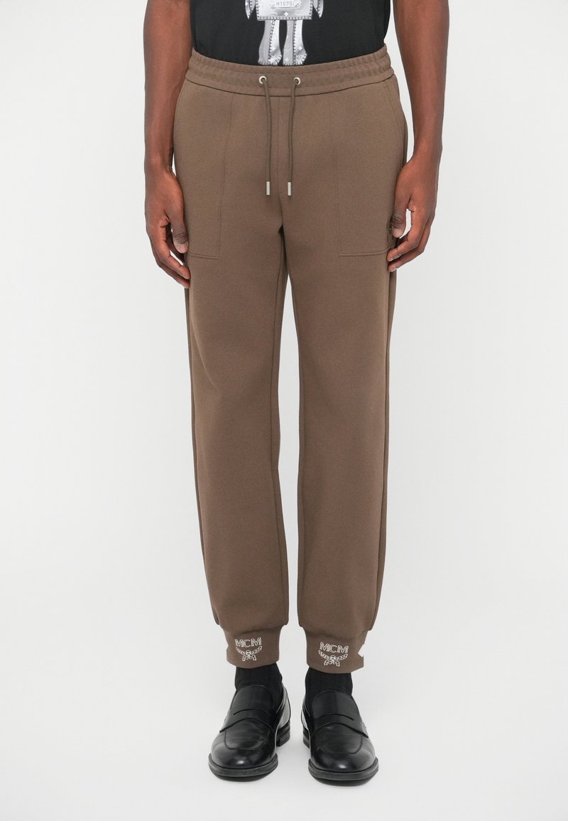 Bruine sweatpants met elastische tailleband en verstelbare trekkoorden. Voorzien van zijzakken en geborduurd MCM-logo bij de mouwen.
