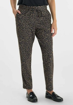 Leopard print trousers in brown and black, featuring an elastic waistband, drawstring, and side pockets, styled with black loafers.