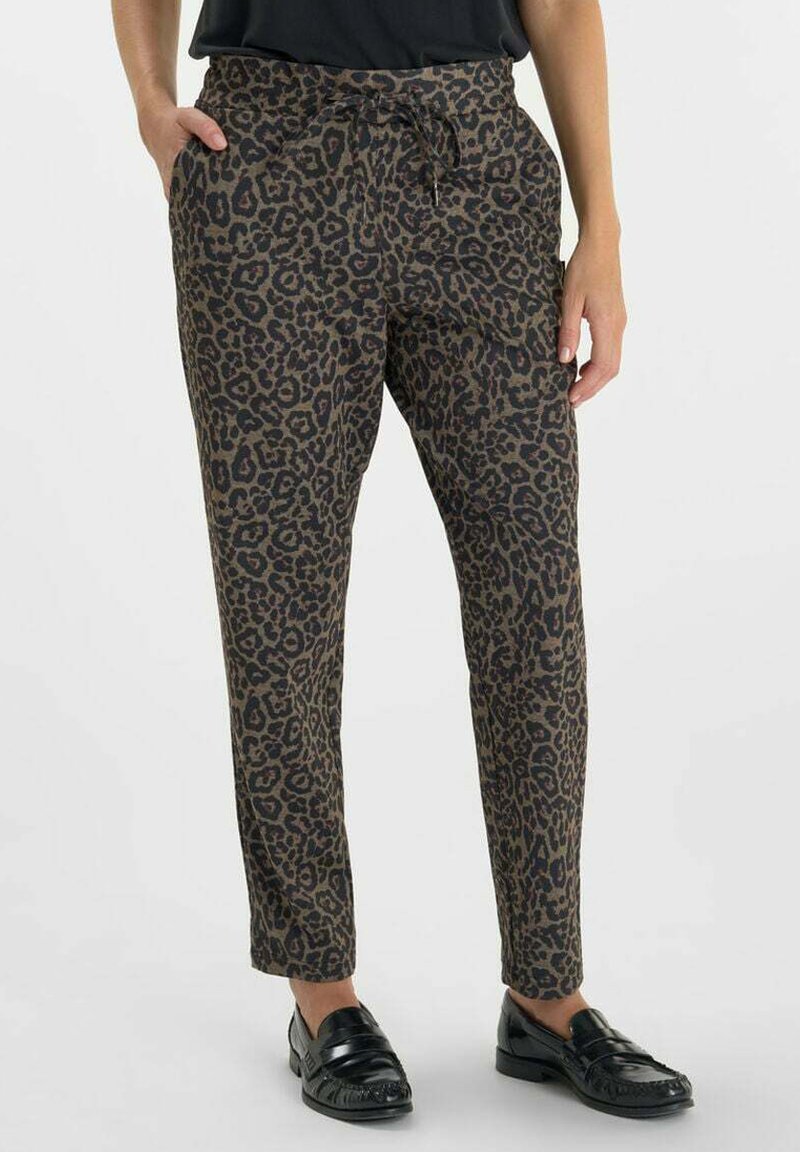 Luipaardprint broeken in bruin en zwart, met een elastische tailleband, trekkoord en zijzakken, gestyled met zwarte loafers.