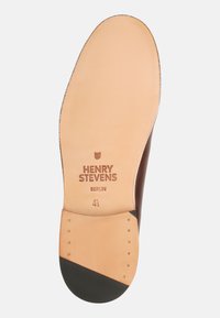 Semelle de chaussure en cuir marron avec une finition beige lisse ; présente le nom de marque embossé "HENRY STEVENS", taille "4½", et un accent noir sur le bout.