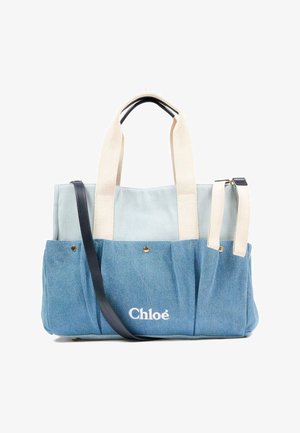 Sac fourre-tout en denim bleu clair avec des poignées beige, une bandoulière noire et un logo blanc "Chloé" sur la poche avant.