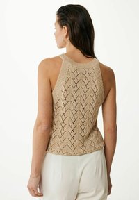 Stickad linne i beige med ett chevronmönster i spets, med rundad halsringning och ärmlös design. Slät textur och avslappnad passform.