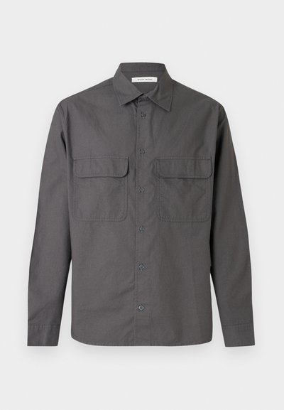 Γκρι πουκάμισο με μακριά μανίκια, κουμπιά, γιακά και δύο εμπρόσθιες τσέπες με καπάκι, παρουσιάζεται σε απλό φόντο.