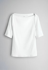 Balts ribots tops ar kvadrātveida kakla izgriezumu, trīs ceturtdaļu piedurknēm un brīvu piegriezumu. Gluda tekstūra, bez redzamiem rakstiem vai akcentiem.