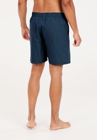 Shorts de bain bleu marine avec une taille élastique, des poches latérales et une coupe droite. Fabriqués en matériau léger et lisse.