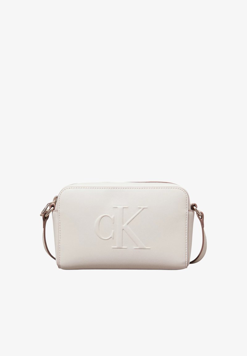 Calvin Klein cream faux leather crossbody bag with embossed logo, rectangular shape, zip closure, adjustable strap, and stitched detailing.