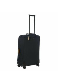 Valigia in tessuto blu navy con manico nero retrattile, quattro ruote, chiusura a zip e dettagli in pelle marrone sul manico laterale.