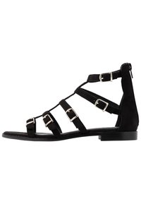 Mustat mokkanahkasaappaat, joissa on useita hihna-aittimia, hopeiset soljet, tasapohja ja vetoketjukiinnitys takana.